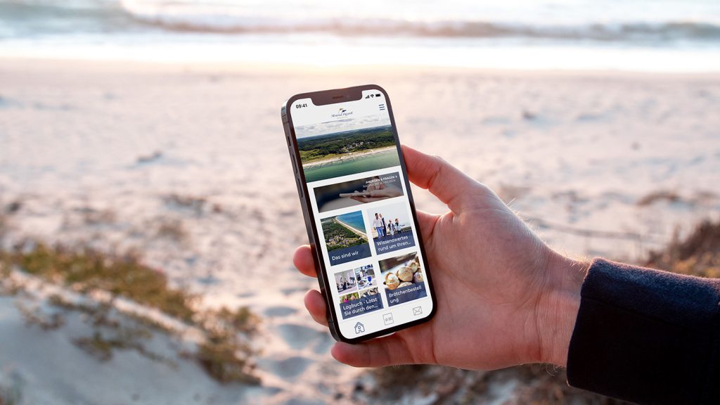 Hote-App StrandResort Amrkgrafenheide, Smartphone am Strand