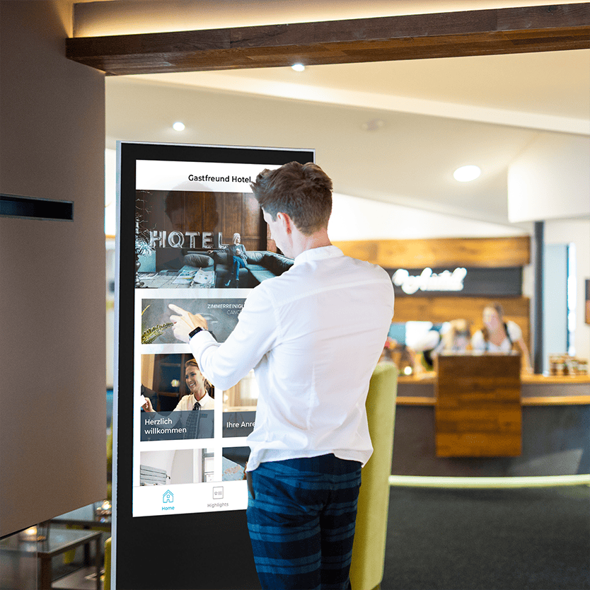 Touchscreen-Kiosk mit Person an Hotel-Rezeption