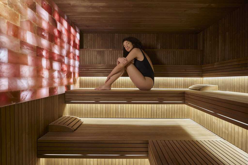 Im Six Senses genießt eine Frau ihre Auszeit in der Sauna und lässt sich von der wohltuenden Wärme des Spa verwöhnen.