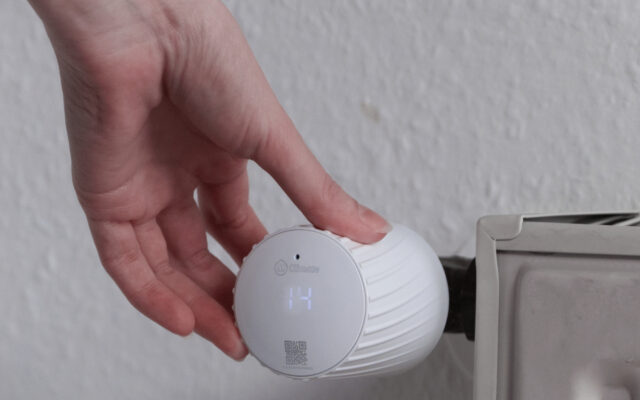 themrostat mclimate an heizkörper wird von person gedreht